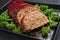 Traditional American meatloaf from ground beef with ketchup and broccoli on a rustic metal tray