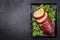 Traditional American meatloaf from ground beef with ketchup and broccoli on a rustic metal tray