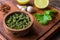 Traditional Argentinian chimichurri sauce against wooden background.