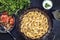 Traditional Armenian manti with mincemeat and paprika salad in a wrought-iron pan