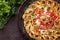 Traditional Armenian manti with mincemeat and paprika salad in a wrought-iron pan