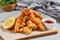 Traditional asian appetizer - crispy shrimps with sauce. Tempura shrimps on wooden board. Prawn tempura in panko breaded with