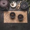 Traditional Asian green tea setting with black iron teapot, cups, candle and honey on dark rustic background with copy space, top