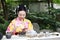 Traditional Asian Japanese beautiful Geisha woman wears kimono show tea art ceremony drink tea in a summer spring outdorr garden