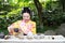 Traditional Asian Japanese beautiful Geisha woman wears kimono show tea art ceremony drink tea in a summer spring outdorr garden