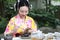 Traditional Asian Japanese beautiful woman conduct tea ceremony in outdoor garden
