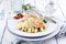 Traditional Atlantic fried salmon filet white asparagus in sauce hollandaise and tomatoes on a classic design plate