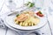 Traditional Atlantic fried salmon filet white asparagus in sauce hollandaise and tomatoes on a classic design plate