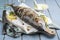 Traditional Australian barbecue bonito fisch with tzatziki and lemon slices on a rustic wooden board