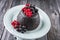 Traditional Australian plum pudding fresh forest berries on a design plate on a wooden table