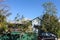 Traditional Australian Queenslander house trimmed in green and red on a hill with tall gum trees