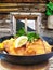 Traditional austrian food Wiener schnitzel against traditional cottage in Kaprun, Austria