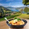 Traditional austrian food Wiener schnitzel against Zell am see village with lake in Austria