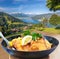 Traditional austrian food Wiener schnitzel against Zell am see village with lake in Austria