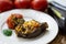 Traditional azerbaijani eggplant dolma also called three sisters made vegan: an aubergine and a tomato stuffed with spicy rice and