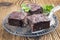 Traditional baked American brownies on a rustic cake plate on a wooden board