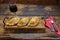 Traditional baked Argentine and Uruguay empanadas savoury pastries with meat beef stuffing against wooden background