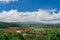 Traditional Balinese village in the valley of the mountains. Orange roofs of houses, coconut palms and rice fields against the