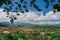 Traditional Balinese village in the valley of the mountains. Orange roofs of houses, coconut palms and rice fields against the