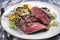 Traditional barbecue angus sirloin beef steak with artichoke hearts and pattypan squashes on a classic design