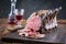 Traditional barbecue dry aged angus cote de boeuf block with cold cuts slices and a glass of red wine on a rustic board