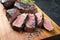 Traditional barbecue dry aged sliced wagyu sirloin beef steak with spice and herbs on modern design wooden design board