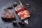 Traditional barbecue dry aged wagyu rib-eye beef steaks with charred onion sliced on a rustic large knife