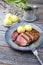 Traditional barbecue gourmet duck breast filet with skin with potato dumplings in dark beer sauce on a design plate