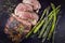 Traditional barbecue lamb roast with green asparagus on an old rustic metal board