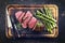 Traditional barbecue wagyu beef point steak with green asparagus on burnt cutting board