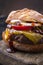 Traditional barbecue wagyu cheeseburger with onions and tomatoes on a cutting board