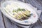 Traditional barbecued white asparagus with violet head garnished with herbs on a design shabby chick plate