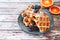 Traditional belgian waffles with blueberries on blue plate and blood oranges