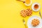 Traditional belgian waffles with honey and tea on served yellow table background top view mockup