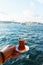 Traditional black Turkish tea in a glass on a plate in the hands with a view of the Bosporus and Istanbul.