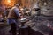 Traditional blacksmith manually forging the molten metal