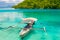 Traditional boat floating on the transparent blue toned lagoon of the remote Togean or Togian Islands, Central Sulawesi, Indones