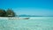 Traditional boat transportation on the shallow sea with transparent clear and island in distance