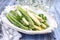 Traditional boiled green and white asparagus on a design plate on a rustic wooden table