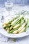 Traditional boiled green and white asparagus offered as side dish on a classic bone China style plate