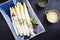 Traditional boiled white asparagus with sauce hollandaise on a blue design plate