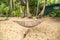 Traditional braided hammock in the shade with tropical island in the background