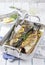 Traditional braised Atlantic loup de mer with lemon slice and herbs in a design skillet