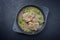 Traditional braised Italian ossobuco alla Milanese with baby broccoli and herb in white wine meat sauce in a cast-iron design pan