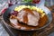 Traditional braised marinated German Sauerbraten from beef with spaetzle and cranberry jam in spicy brown sauce