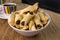 Traditional Brazilian buttered cookies stuffed with guava paste called goiabinha ou beliscÃ£o in a white bowl in wood bakground