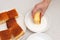 Traditional Brazilian dessert known as BOLO GELADO in Portuguese - Making step by step: Hand watering cake in bowl with milk