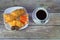 Traditional breakfast, a cup of black coffee and a plate of croissants, orange slices and chocolates. Close-up