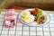 traditional breakfast on a plate on a table with a plaid tablecloth.