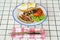 traditional breakfast on a plate on a table with a plaid tablecloth.